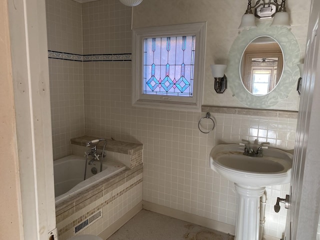 full bathroom featuring a tub and tile walls