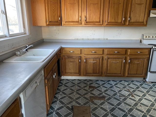 kitchen featuring dishwashing machine, a sink, light countertops, white range with electric stovetop, and brown cabinetry