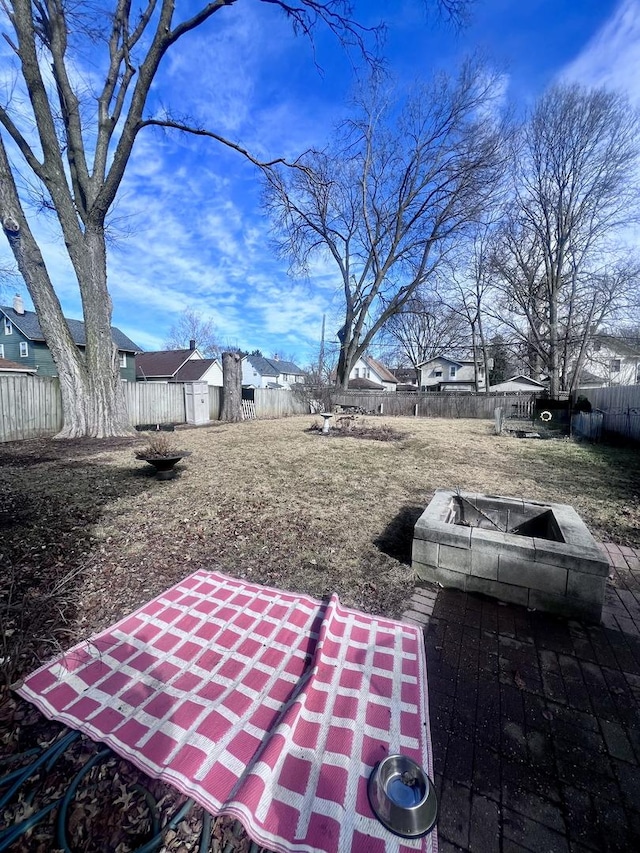 view of yard with an outdoor fire pit, a storage unit, a fenced backyard, and an outdoor structure