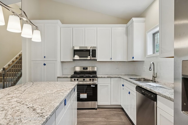 5912 Prairie Ridge Rd, Crystal Lake, IL 60014 - kitchen with stainless steel appliances, vaulted ceiling, white cabinets, wood finished floors, and tasteful backsplash