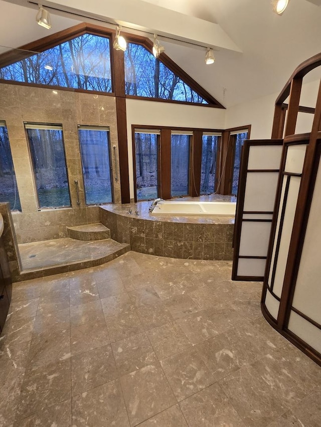 full bathroom with vaulted ceiling and a garden tub