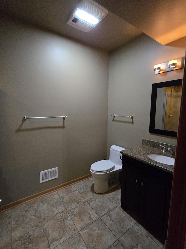 bathroom with baseboards, visible vents, vanity, and toilet