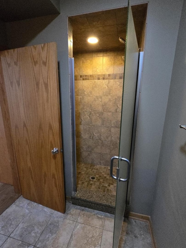 bathroom with a stall shower and baseboards