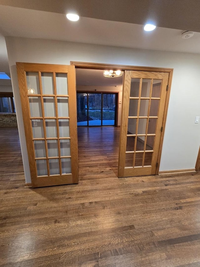 hallway featuring baseboards, wood finished floors, and recessed lighting