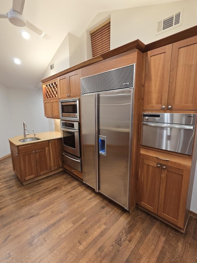 kitchen with visible vents, built in appliances, a peninsula, a sink, and a warming drawer