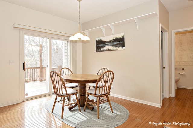 dining space with light wood-style flooring and baseboards