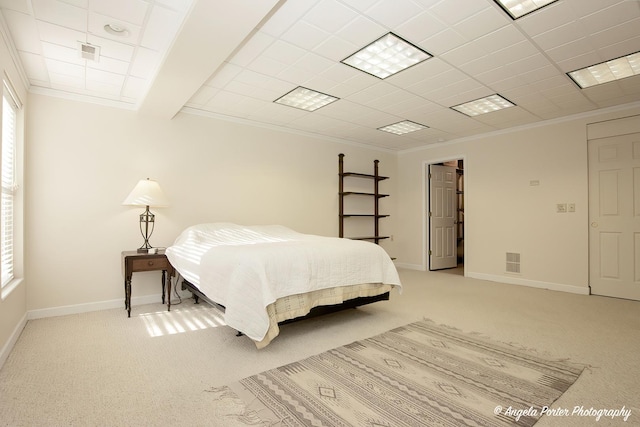 bedroom with baseboards, light colored carpet, visible vents, and crown molding