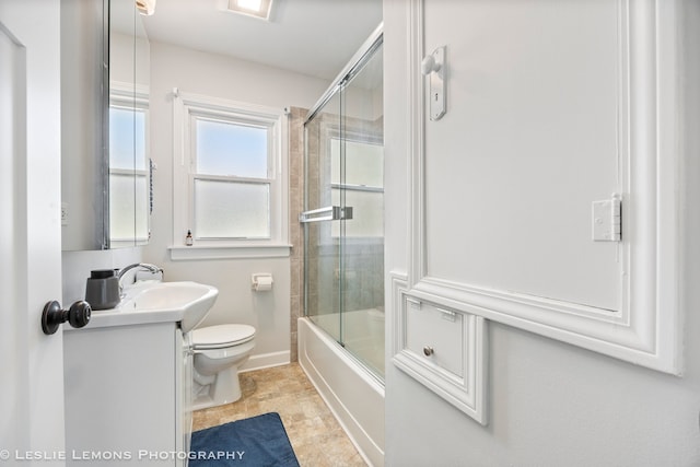 bathroom featuring vanity, toilet, and bath / shower combo with glass door