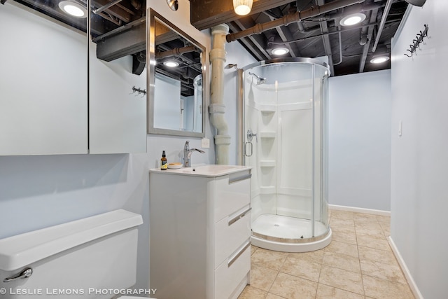 full bath featuring toilet, vanity, baseboards, a shower stall, and tile patterned floors