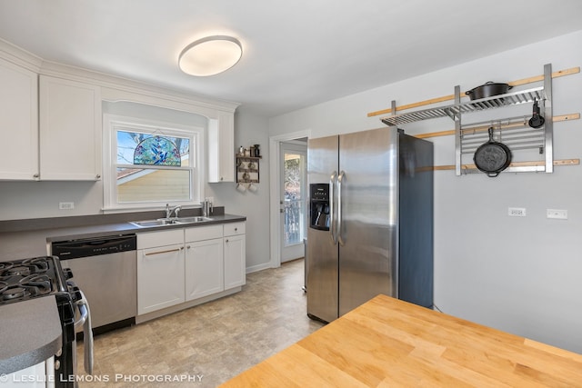 kitchen featuring appliances with stainless steel finishes, white cabinetry, and a sink