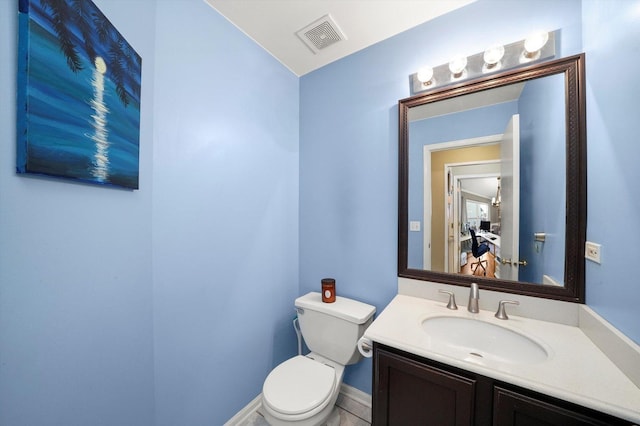 bathroom featuring toilet, vanity, baseboards, and visible vents