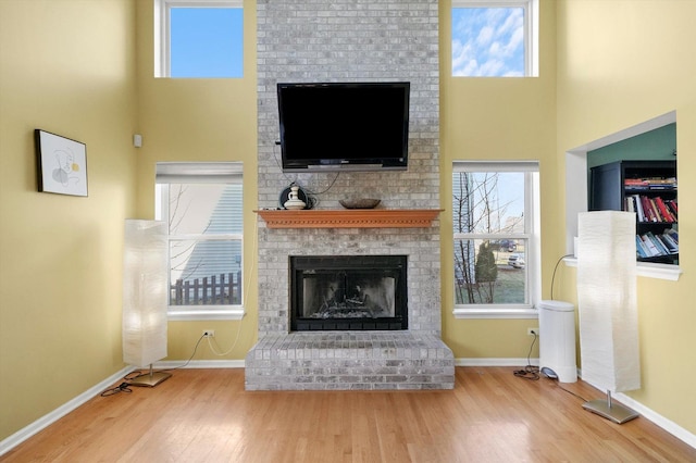 unfurnished living room with a fireplace, wood finished floors, and a healthy amount of sunlight