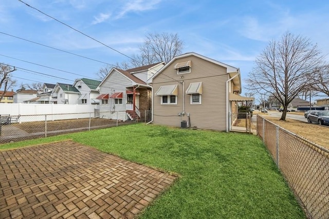 rear view of property with a yard, a patio, a fenced backyard, and central air condition unit