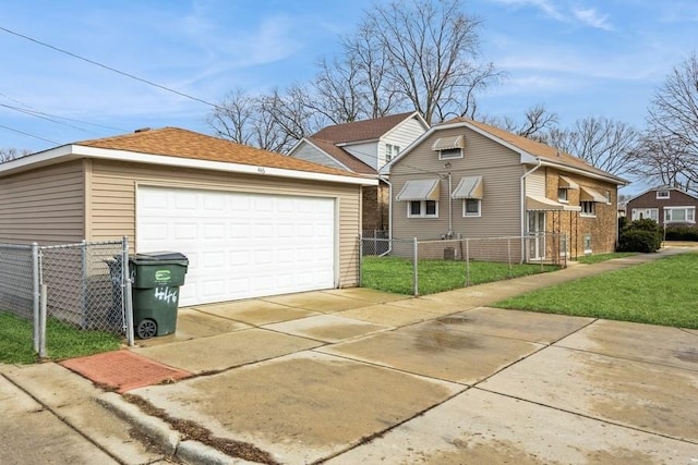 view of front of property with a detached garage, fence, a front lawn, and an outbuilding