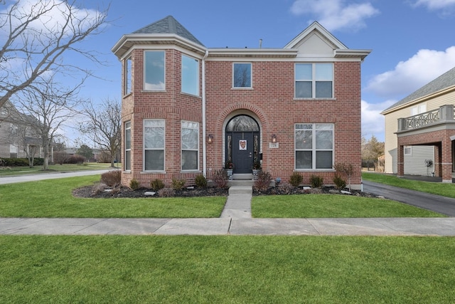 view of front facade with brick siding and a front lawn