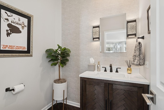 bathroom with wood finished floors, vanity, and baseboards