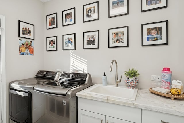 washroom featuring washer and clothes dryer, a sink, and cabinet space