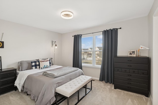 bedroom featuring light carpet and baseboards