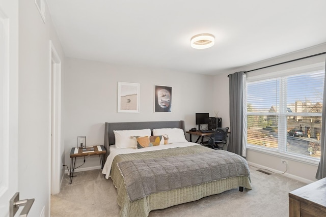 bedroom featuring light carpet, visible vents, and baseboards