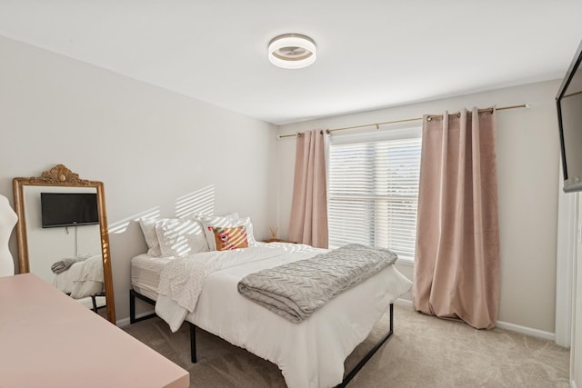 bedroom with light carpet and baseboards