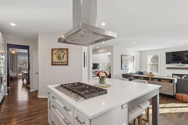 kitchen with white cabinets, open floor plan, dark wood-style flooring, island exhaust hood, and stainless steel gas stovetop