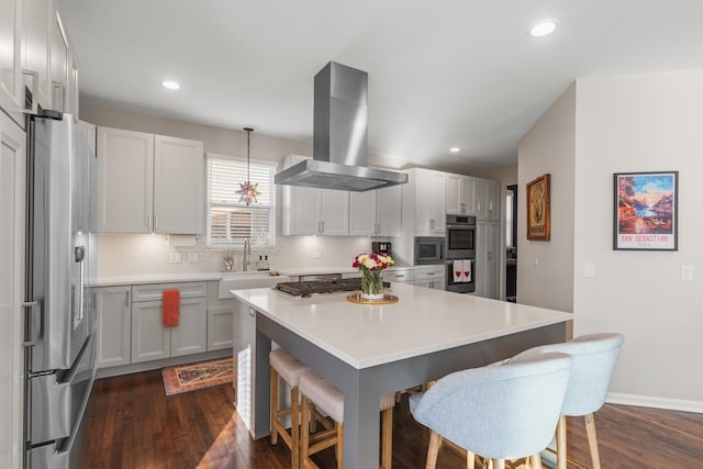 kitchen with extractor fan, a sink, appliances with stainless steel finishes, decorative backsplash, and a kitchen bar