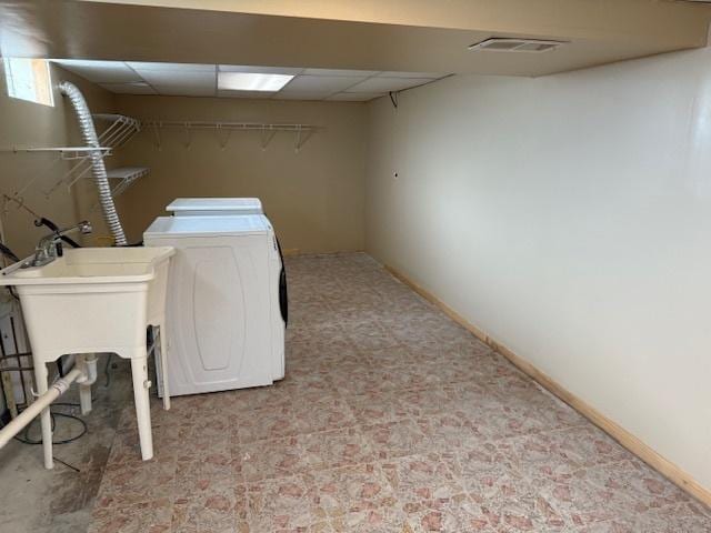 clothes washing area featuring laundry area, washer and clothes dryer, visible vents, and baseboards