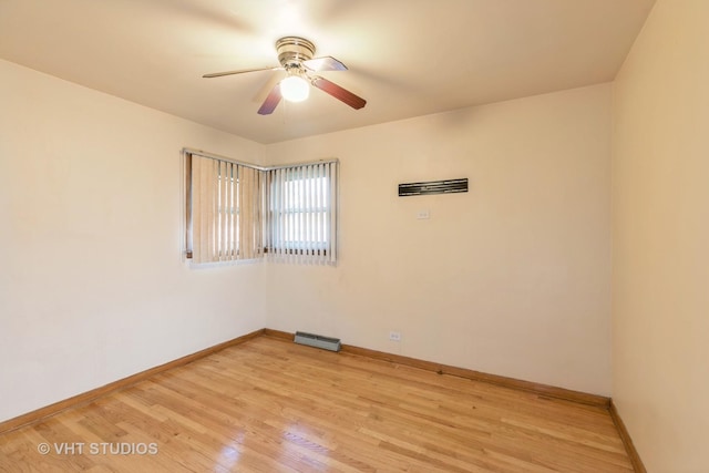 spare room with ceiling fan, light wood finished floors, visible vents, and baseboards