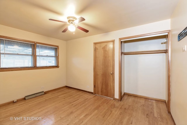 unfurnished bedroom featuring light wood-style flooring, a ceiling fan, baseboards, baseboard heating, and a closet