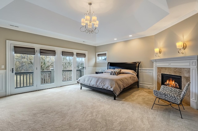 bedroom featuring a wainscoted wall, visible vents, carpet, a fireplace, and access to exterior