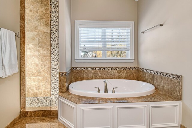 full bathroom featuring tiled shower, a bath, and tile patterned flooring