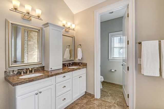 full bath featuring a sink, baseboards, toilet, and double vanity