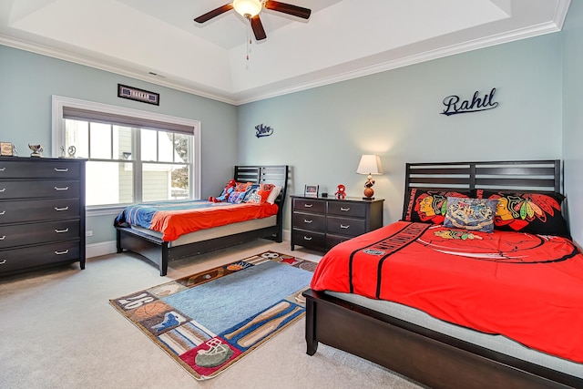 bedroom featuring ornamental molding, a raised ceiling, a ceiling fan, and carpet floors