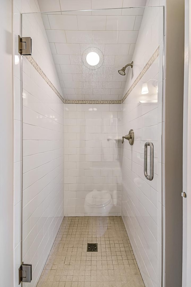 bathroom featuring a shower stall and lofted ceiling