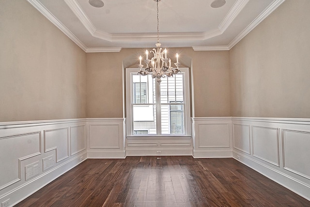 unfurnished dining area featuring a chandelier, a tray ceiling, and dark wood-style flooring