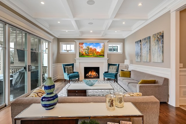 interior space featuring a wainscoted wall, beam ceiling, coffered ceiling, wood finished floors, and a lit fireplace