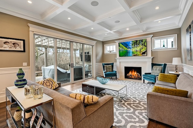 living room with beam ceiling, coffered ceiling, and a lit fireplace