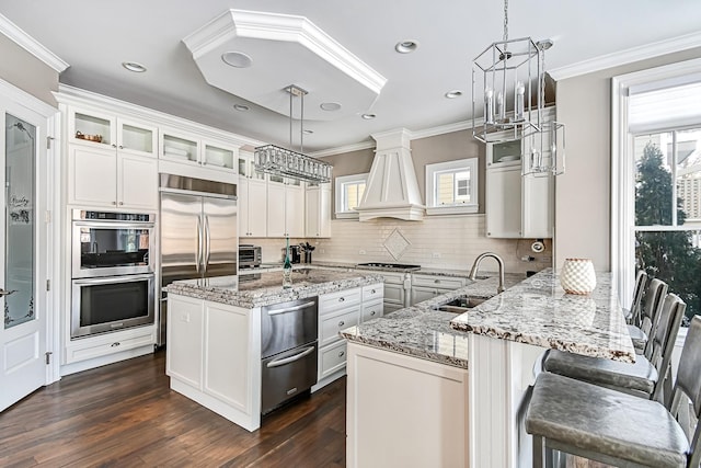 kitchen with ornamental molding, stainless steel appliances, a warming drawer, and a sink