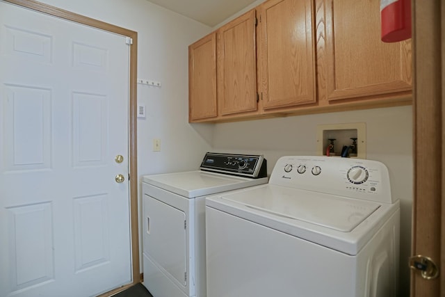 washroom featuring cabinet space and washer and clothes dryer