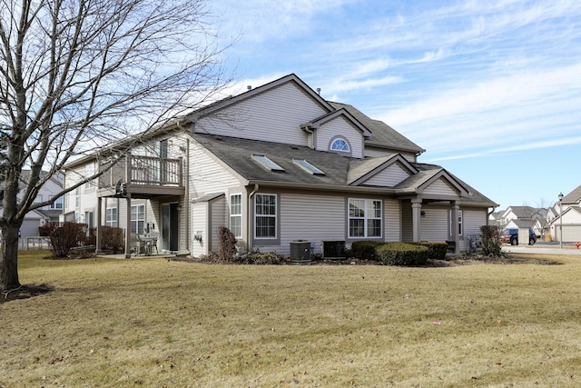 view of front of home with cooling unit, a balcony, and a front lawn