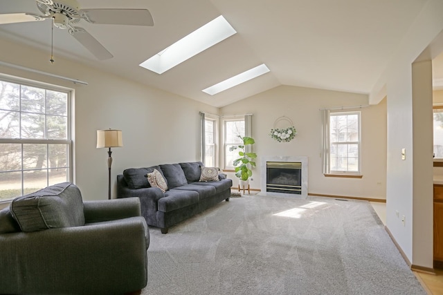 living area featuring lofted ceiling, baseboards, light colored carpet, and a high end fireplace