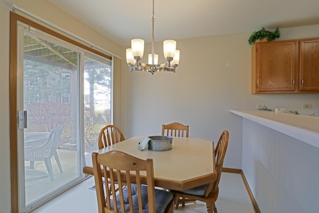 dining space featuring a notable chandelier and baseboards