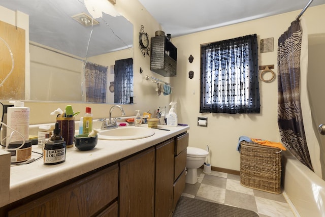 full bathroom featuring vanity, toilet, and baseboards