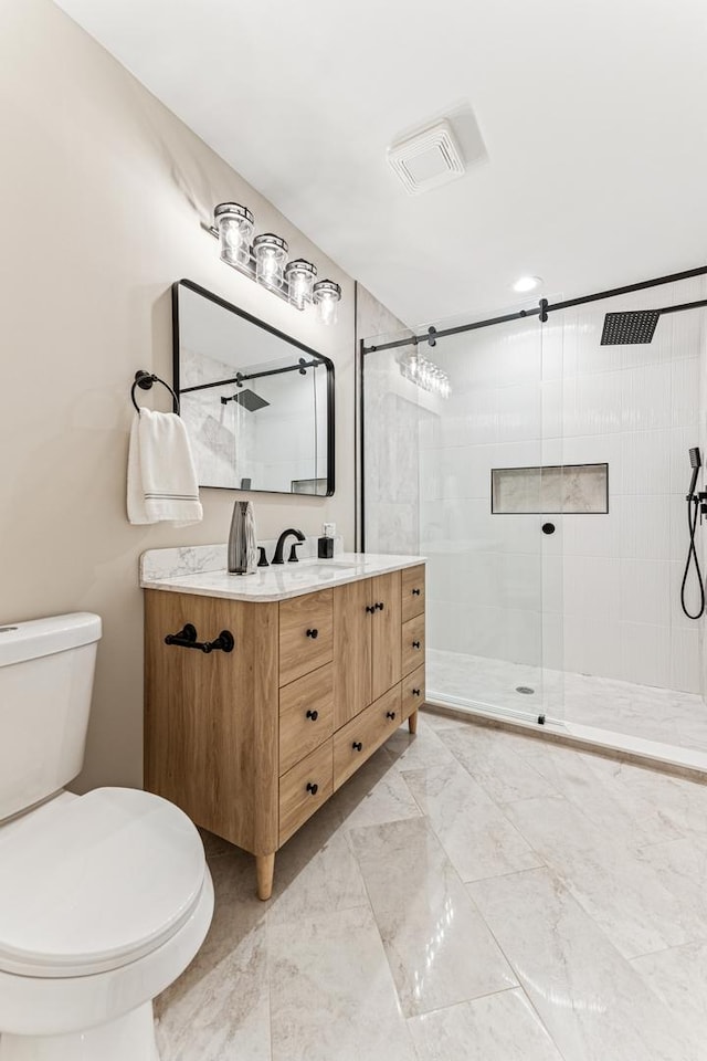 bathroom with a stall shower, visible vents, toilet, marble finish floor, and vanity