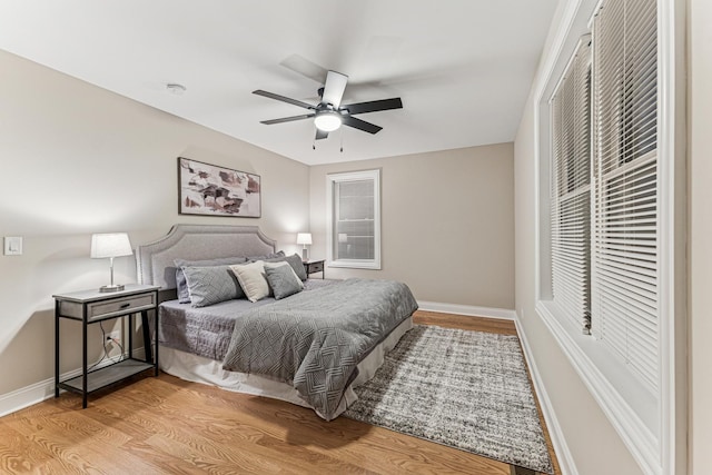 bedroom featuring light wood-style floors, baseboards, and a ceiling fan