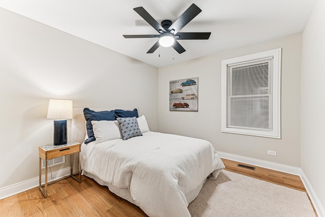 bedroom with light wood-style floors, visible vents, and baseboards