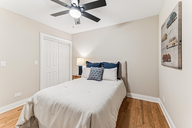 bedroom with a closet, ceiling fan, baseboards, and wood finished floors