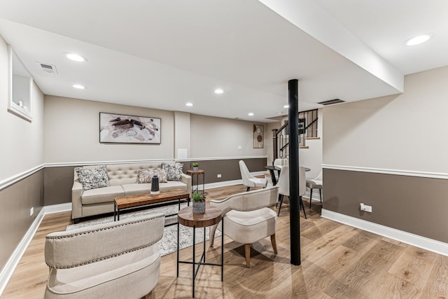 living room with light wood-type flooring, stairway, and recessed lighting