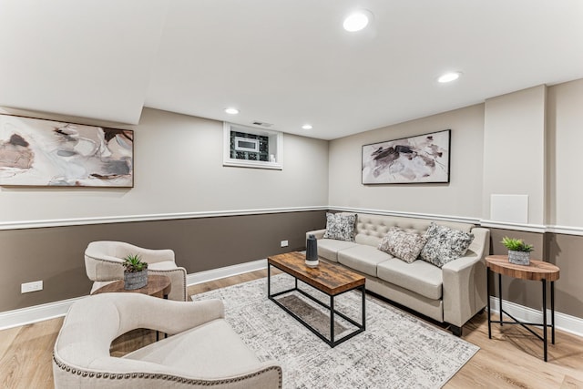 living area with baseboards, wood finished floors, and recessed lighting