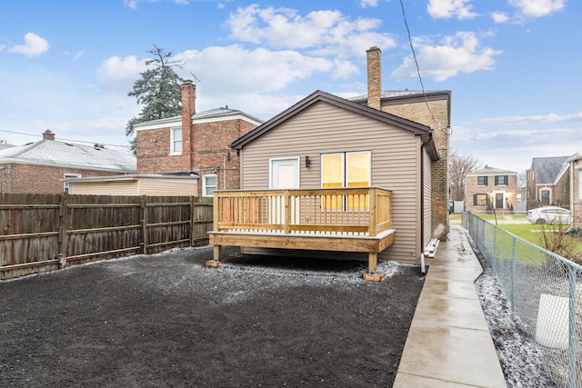 back of house with a fenced backyard, brick siding, and a deck